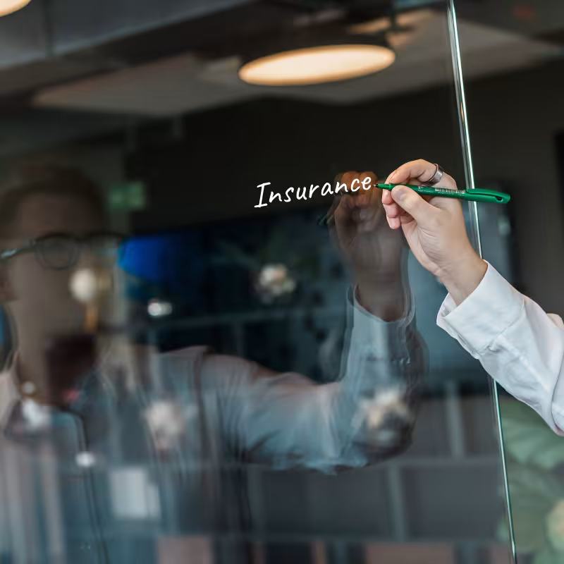 Hand schreibt „Innovation“ mit grünem Marker auf Glaswand im Büroce