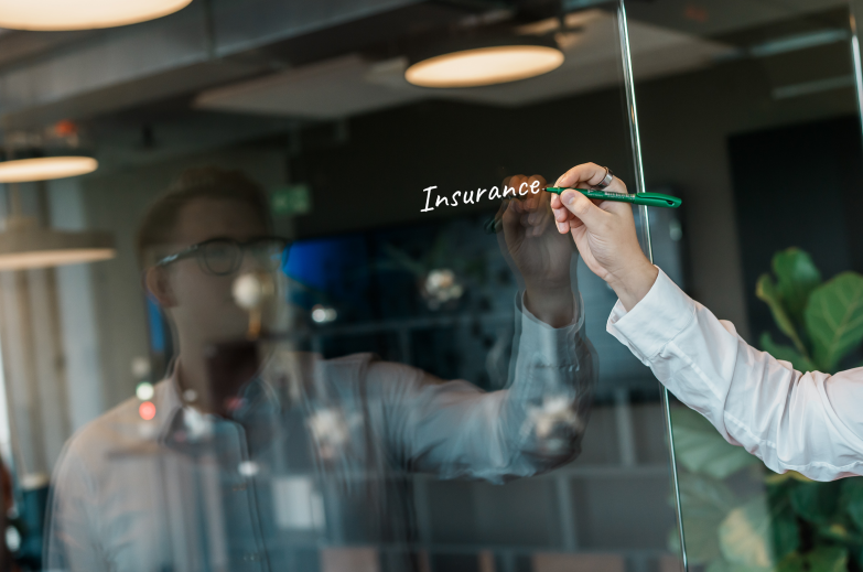 Hand schreibt „Innovation“ mit grünem Marker auf Glaswand im Büroce
